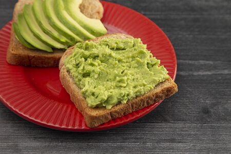 Avocado Toast on a Red Plate on a Rustic Wooden Table