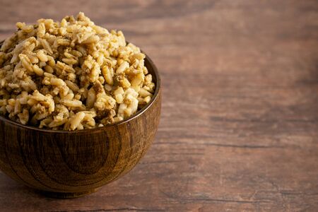 A Bowl of Cajun Dirty Rice on a Rustic Wooden Tableの写真素材