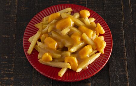 Poutine with Orange Cheddar Cheese with Brown Gravy on French Fries