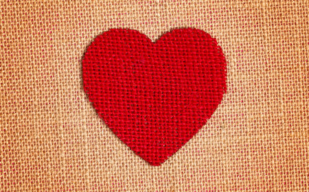 One Red Burlap Heart on a Brown Backgroundの写真素材