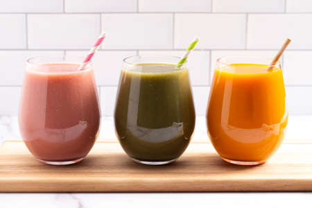 Three Varieties of Healthy Smoothies on a Bright Kitchen Cabinetの写真素材