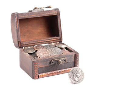 A Treasure Chest Filled with Ancient Coins on a White Backgroundの写真素材