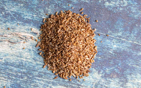 Pile of Bulgur Wheat on a Rustic Blue Table