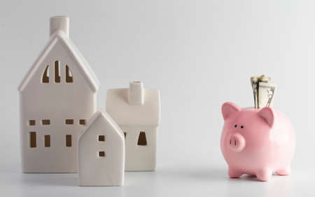 Houses and a Piggy Bank on a White Backgroundの写真素材