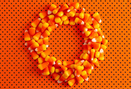 Halloween Wreath Made out of Candy Corn on a Orange and Black Polkadot Background