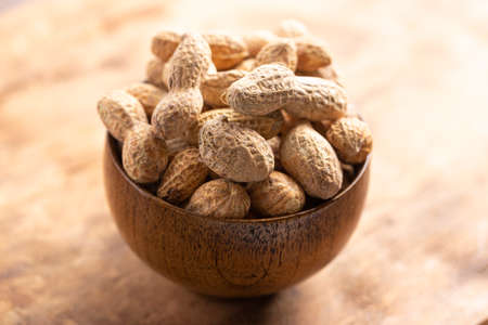 A Bowl of In Shell Peanut on a Dark Wooden Table