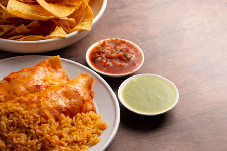 A Pair of Enchiladas with Red Sauce and Seasoned Riceの写真素材