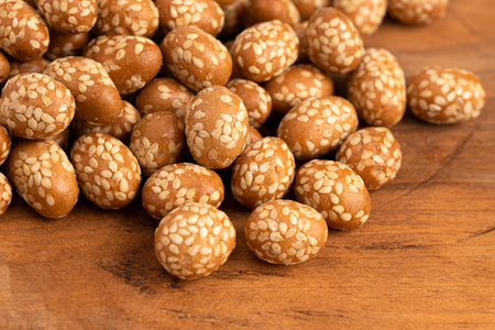 Pile of Crunchy Asian Sesame Peanuts with Soy Sauce on a Wooden Counterの写真素材