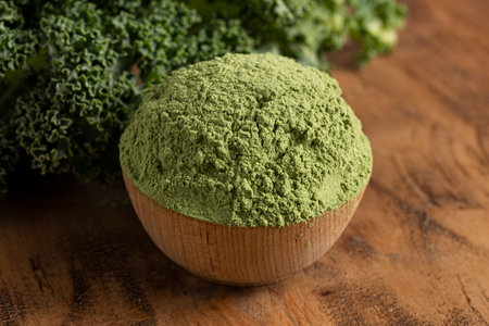 Bowl of Green Kale Powder on a Wooden Counter Topの写真素材