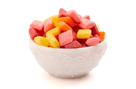 Pile of Rainbow Colored Small Chewy Square Candies Isolated on a White Backgroundの写真素材