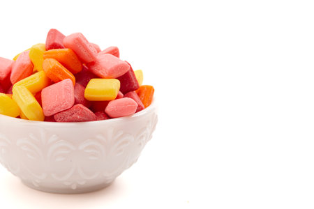 Pile of Rainbow Colored Small Chewy Square Candies Isolated on a White Backgroundの写真素材