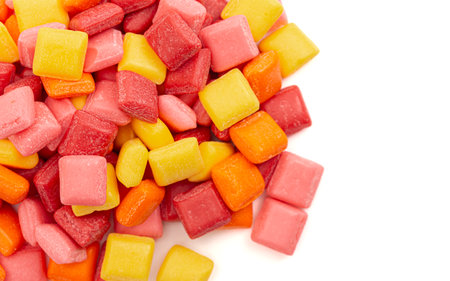 Pile of Rainbow Colored Small Chewy Square Candies Isolated on a White Backgroundの写真素材