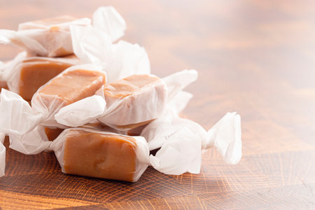 Hand Wrapped Soft Caramel Candies  on a Wooden Block Tableの写真素材