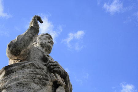 Old giant statue in front of the Basilica of Saints Peter and Paul in EUR district, Rome. Low angle view on cloudy sky.の写真素材