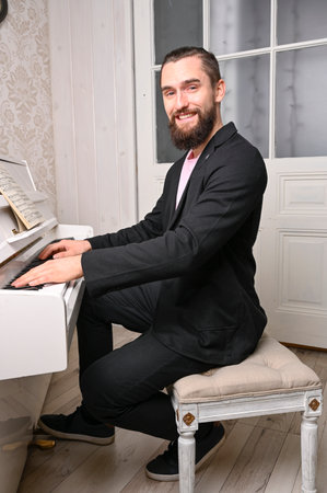 A young well dressed man is playing piano.の写真素材