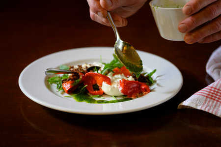 Fresh mozzarella and some paprika get prepared in a fine dining restaurant.の写真素材