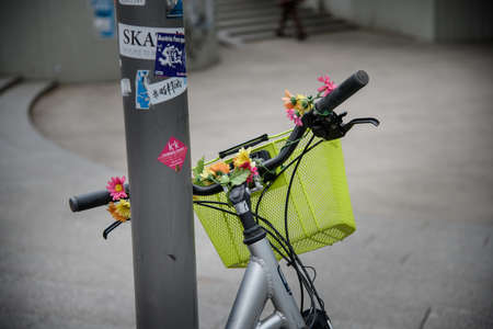 A ladies bike with a large shopping basket on the handlebars is decorated with flowers.の写真素材