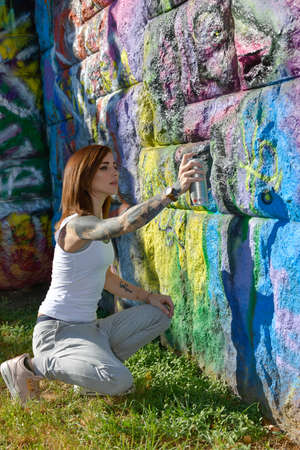 A beautiful young tattooed woman is walking in the city and enjoys the warm summer.の写真素材