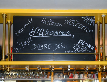 A large hand-lettered notice board that reads "Welcome" in many different languages.の写真素材