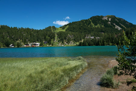 Green shimmering mountain lake with few housesの写真素材