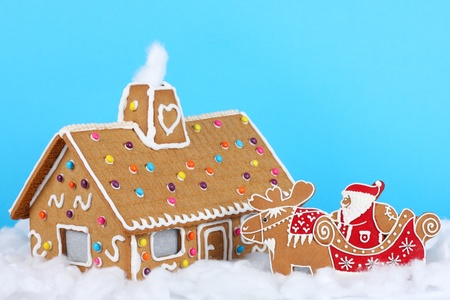 Gingerbread house with Santa Claus on reindeer sledの写真素材