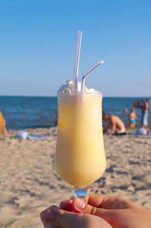 Pina-colada cocktail on the beach in a hand