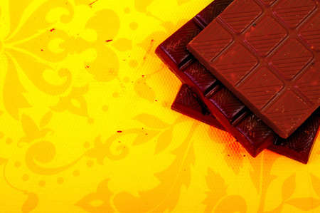 Different chocolate bars on yellow backgroundの写真素材