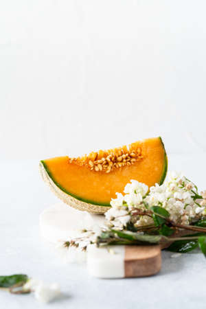 Fresh Cavaillon melon with white flowers on a white background.の写真素材
