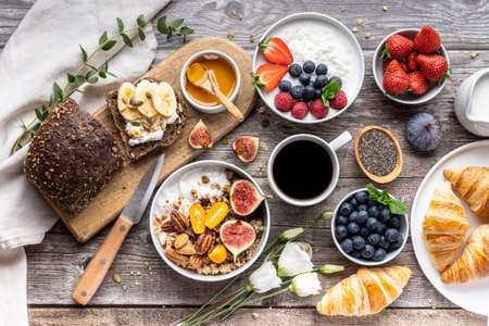 The continental breakfast is captured from above, top view. Coffee, croissants, granola, Belgian...