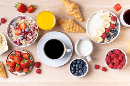 Healthy breakfast set on wooden background. The concept of delicious and healthy food. Mix nuts, honey, berries, orange jus, pancake and milk. Top viの写真素材