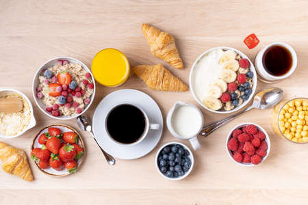 Healthy breakfast set on wooden background. The concept of delicious and healthy food. Mix nuts, honey, berries, orange jus, pancake and milk. Top viの写真素材