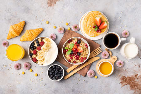 Beautifully served table for breakfast with many delicacies, cheeses, salami, pastries, orange juice, tea and coffee.の写真素材
