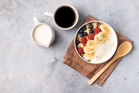 Breakfast table with granola, fresh berries and coffee with milk. Top view.の写真素材