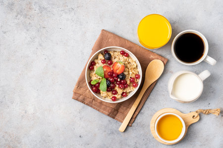 Breakfast table with pancakes, granola, fresh berries and orange juice. Top view.の写真素材