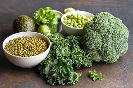 Healthy vegetarian food concept background, fresh green food selection for detox diet, raw broccoli, apple, spinach, peas, avocado, lime, corn salad and grape beanの写真素材