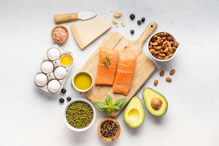 Assortment of healthy protein sources and body building food : fish, vegetables, legumes, nuts, cereals and dairy products on a light slate, stone or concrete background. Top view, copy spaceの写真素材