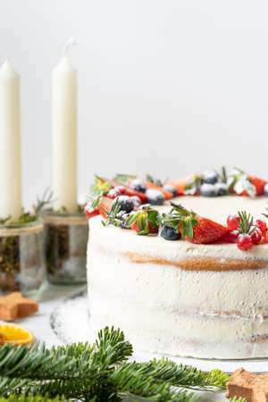 Homemade birthday cake for New year and Christmas. Christmas tree branches for decorating the Christmas table.の写真素材