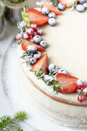 Homemade birthday cake for New year and Christmas. Christmas tree branches for decorating the Christmas table.の写真素材
