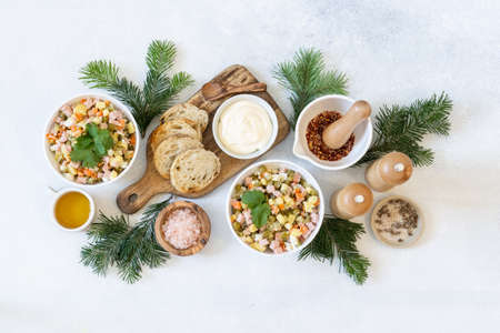 Vegetable salad Olivier in a white bowl with homemade sauce, a festive dish for the new year. Top view.の写真素材
