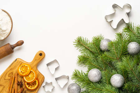 Green branches of the Christmas tree, oranges, ingredients for ginger cookies on a white background, merry Christmas and New Year. Top viewの写真素材