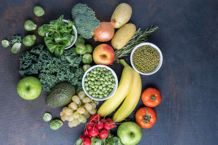 The concept of a healthy vegetarian diet, a selection of fresh products for a detox diet, raw broccoli, apple, spinach, peas, avocado, lime, corn salad, top view. The concept of healthy eating.の写真素材