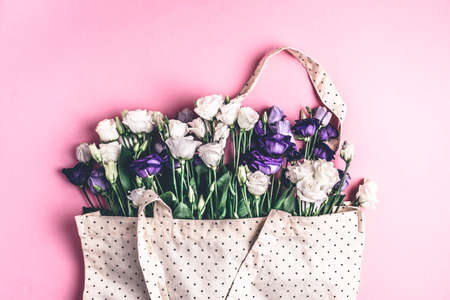 The composition of flowers and bags. A gift and flowers on a pink background. Womens Day, a holiday. Flat sunbed, top view, copy space.の写真素材