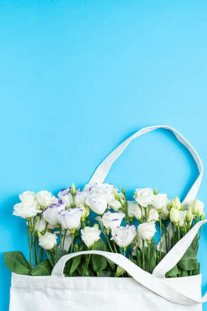 The composition of flowers and bags. A gift and flowers on a blue background. Womens Day, a holiday. Flat sunbed, top view, copy space.の写真素材