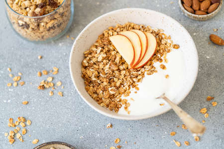 Homemade granola with milk, apples and nuts. Delicious and healthy breakfast.