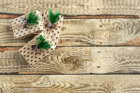 Gifts in festive packaging on a wooden background. Christmas tree branches, decorations, Christmasの写真素材