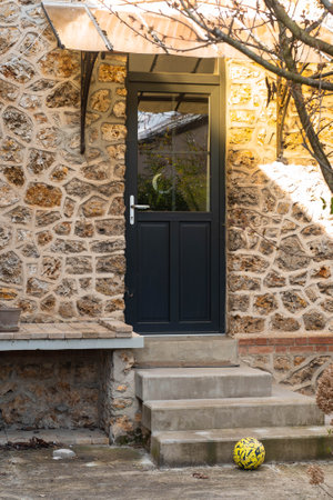 Stone building with wooden door and ball outside.の写真素材