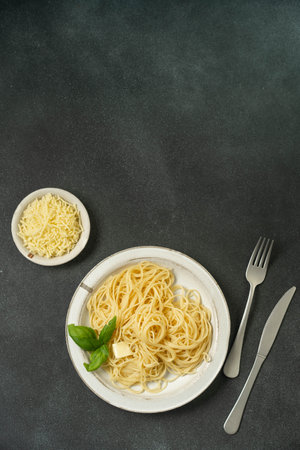 Simple pasta and cheese plate on dark textured surface.の写真素材
