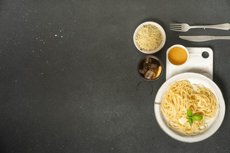Pasta, cheese and drink arranged on elegant black background.の写真素材