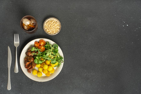 Chicken plate with salad, tomatoes and sesame on dark surface. High quality photoの写真素材