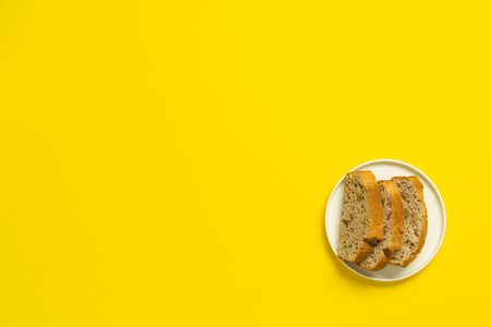 Cake slice on vibrant yellow background flatlay.の写真素材